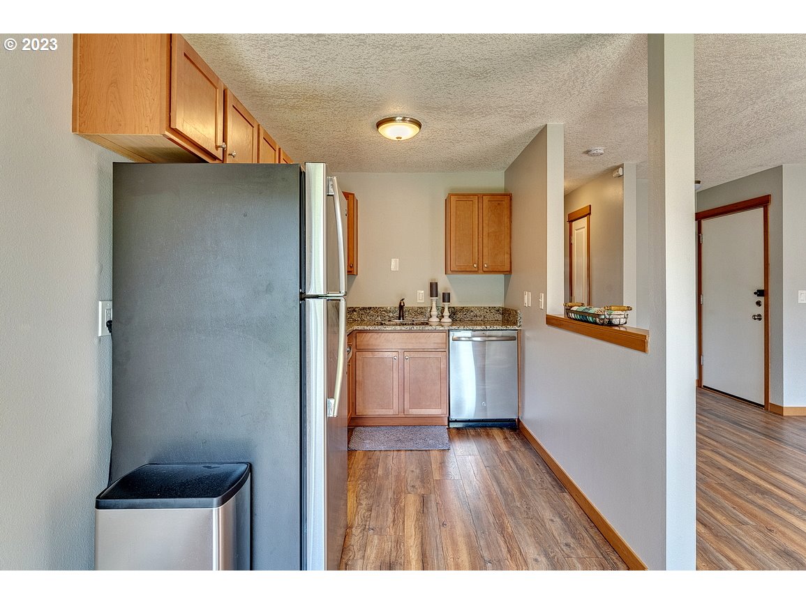 200 Southwest Florence Avenue, Unit C9 Gresham, OR 97080 - Photo 12 of 32 a kitchen with a refrigerator and a wooden cabinets
