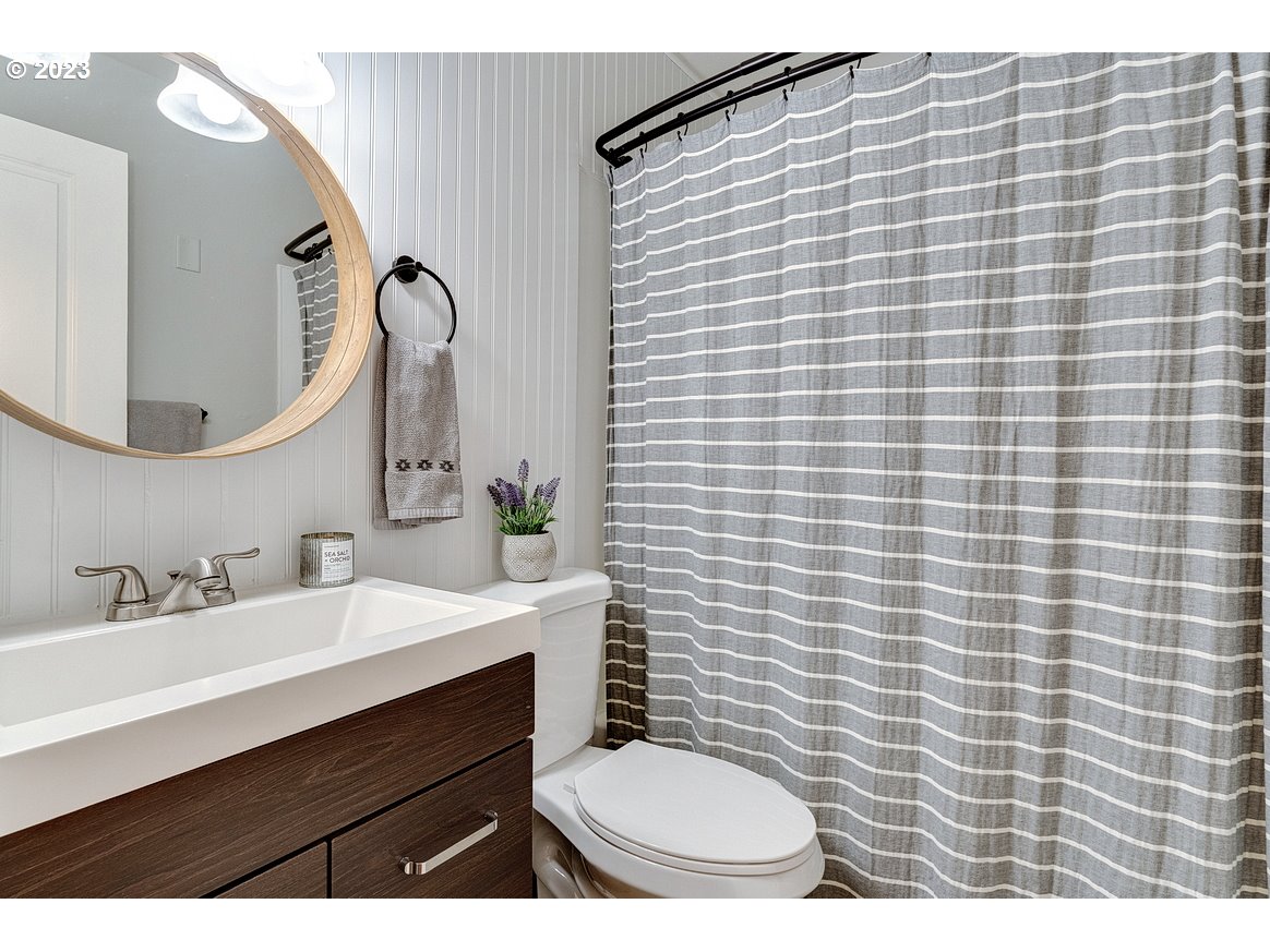 200 Southwest Florence Avenue, Unit C9 Gresham, OR 97080 - Photo 17 of 32 a bathroom with a sink a toilet a mirror and shower curtain