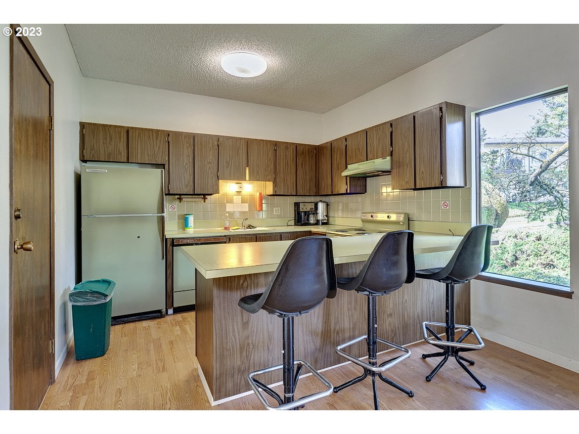200 Southwest Florence Avenue, Unit C9 Gresham, OR 97080 - Photo 31 of 32 a kitchen with stainless steel appliances a dining table chairs refrigerator and sink