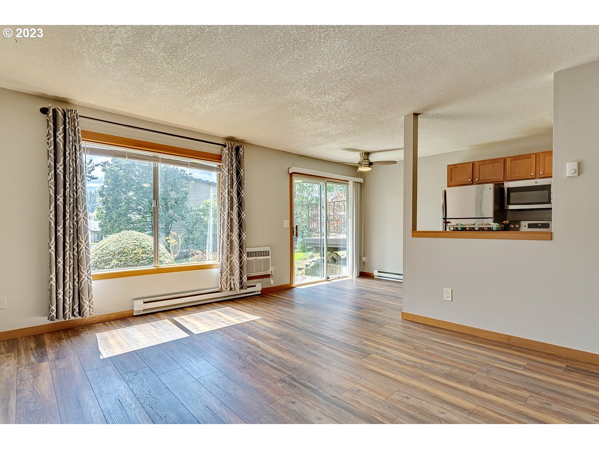 200 Southwest Florence Avenue, Unit C9 Gresham, OR 97080 - Photo 5 of 32 a view of an empty room with wooden floor and a window