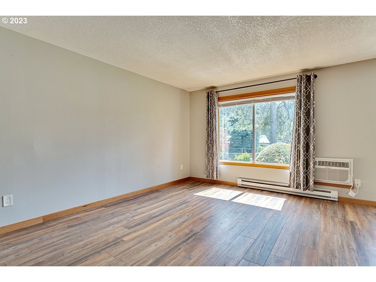 200 Southwest Florence Avenue, Unit C9 Gresham, OR 97080 - Photo 6 of 32 a view of an empty room with wooden floor and a window