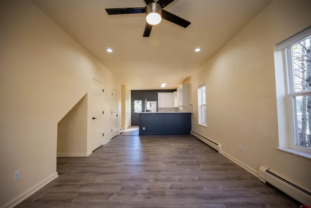 a view of an empty room and window and wooden floor