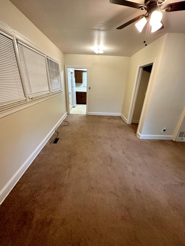 1235 Lockwood Avenue Columbus, GA 31906 - Photo 7 of 11 an empty room with chandelier fan and windows