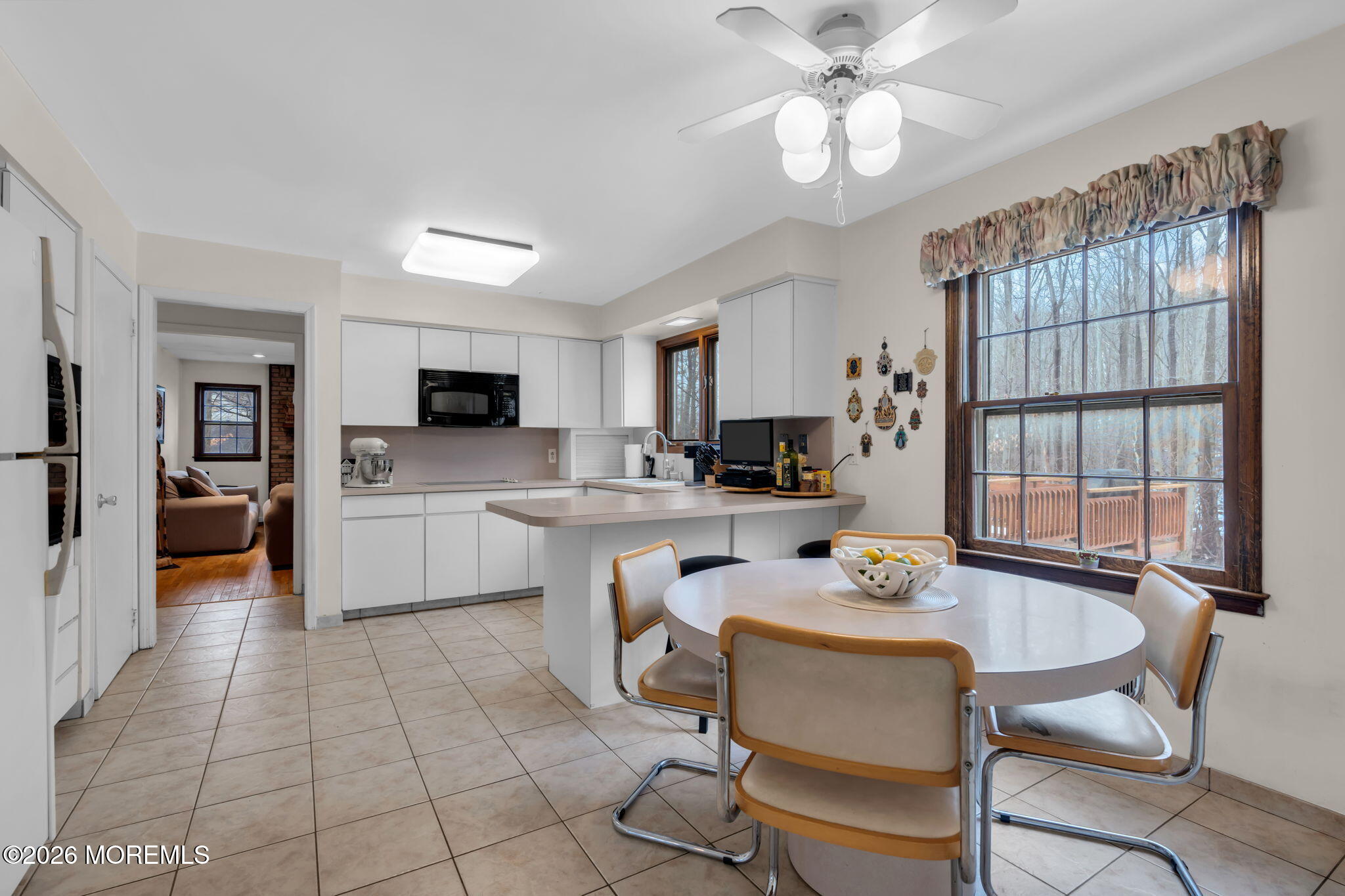 103 Reids Hill Road Morganville, NJ 07751 - Photo 22 of 44 a kitchen with a table chairs sink and cabinets