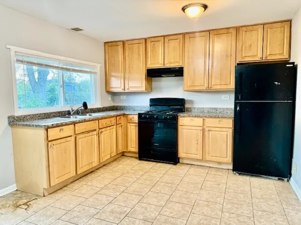 a kitchen with stainless steel appliances granite countertop a stove a sink and a refrigerator