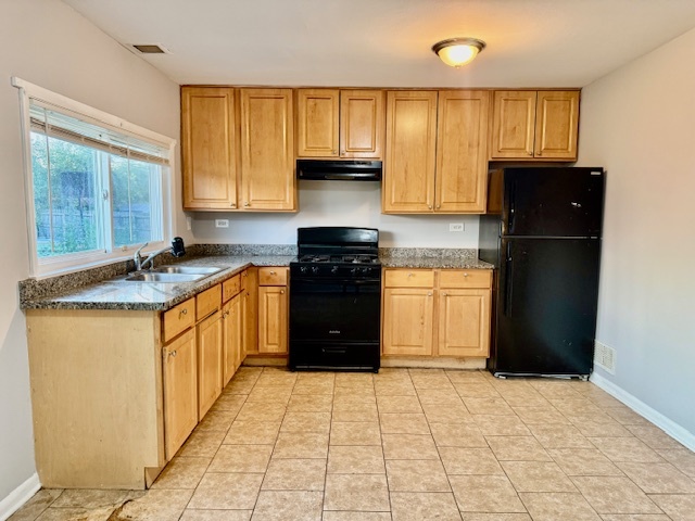 906 Blackhawk Drive University Park, IL 60484 - Photo 7 of 13 a kitchen with granite countertop a refrigerator stove top oven wooden cabinetry and granite counter tops