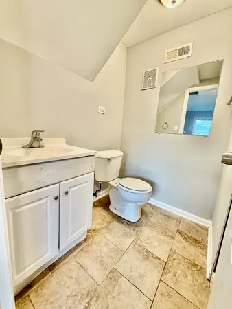 a bathroom with a granite countertop toilet and sink