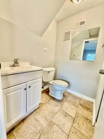 a bathroom with a granite countertop toilet and sink
