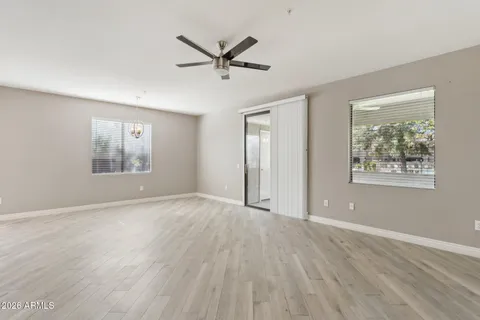a view of an empty room with a window and wooden floor