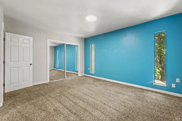 a view of an empty room with window and stairs