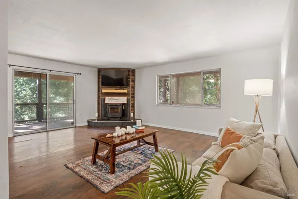 a living room with furniture a rug a lamp and a large window