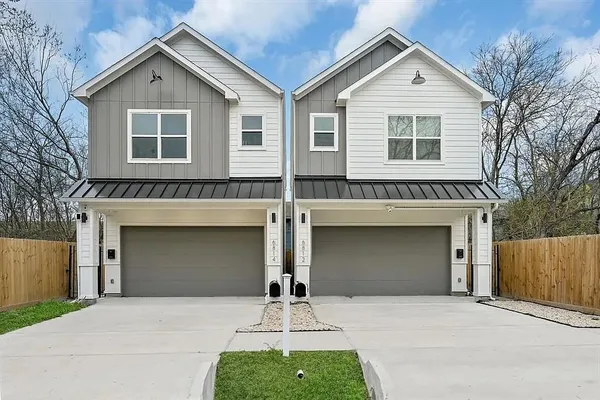 a front view of a house with yard and parking