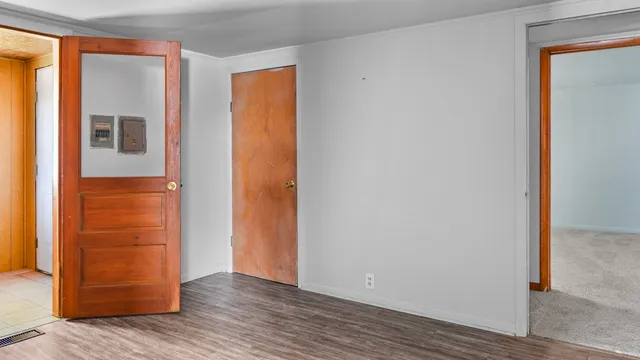 an empty room with wooden floor and entrance