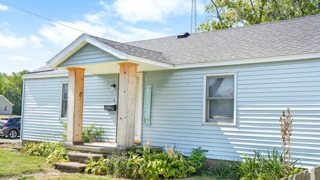 a view of a house with a yard and potted plants