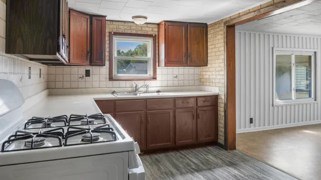 a kitchen with a sink stove and cabinets