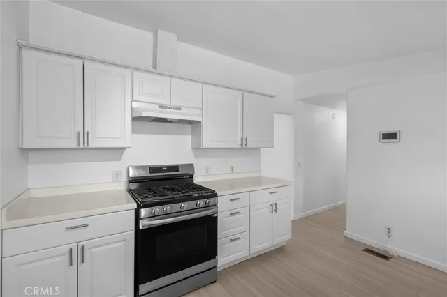 a kitchen with granite countertop white cabinets and white appliances