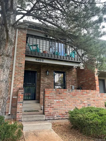 a front view of a house with a tree