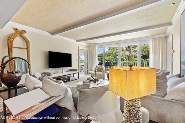 a living room with furniture a flat screen tv and a large window