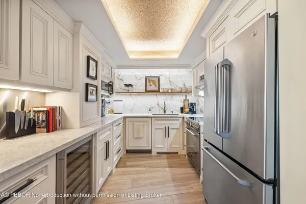 a kitchen with stainless steel appliances granite countertop a refrigerator and a stove top oven