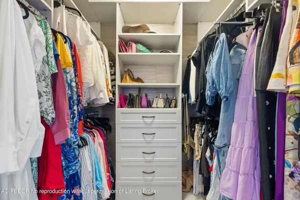a view of walk in closet with clothes