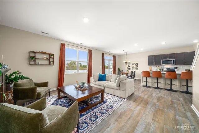 a kitchen with stainless steel appliances granite countertop a table chairs microwave and sink