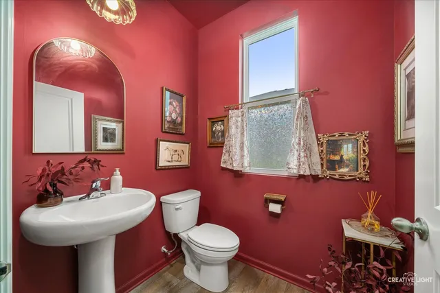 a kitchen with stainless steel appliances granite countertop a refrigerator a stove top oven a sink dishwasher and white cabinets with wooden floor