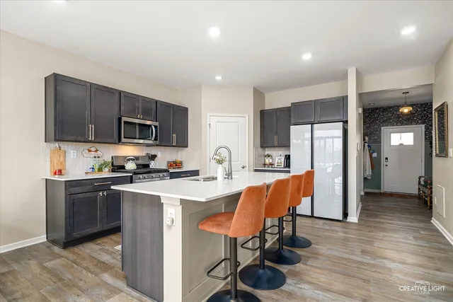 a kitchen that has a lot of cabinets in it and wooden floors
