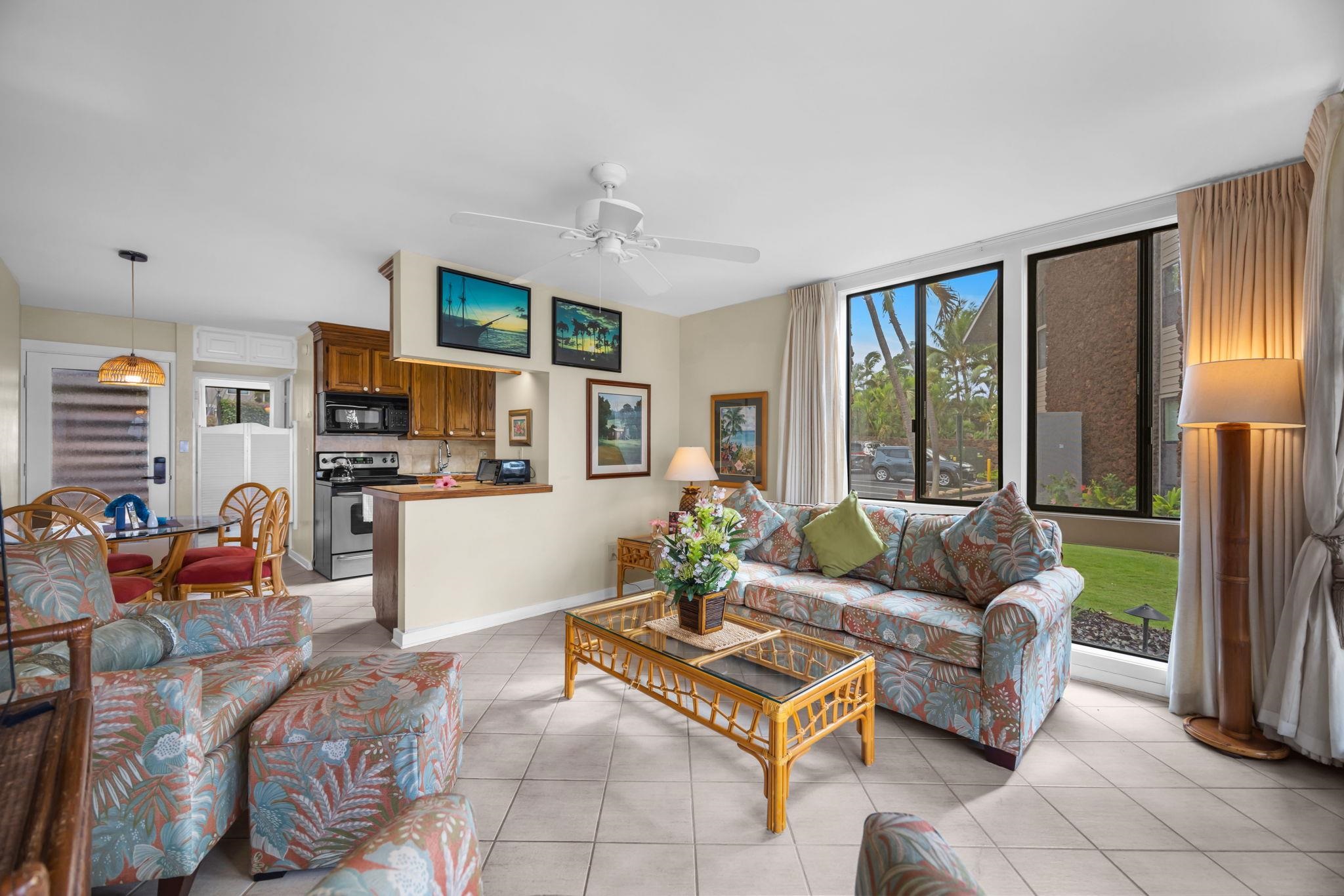 4057 Lower Honoapiilani Road, Unit 116 Lahaina, HI 96761 - Photo 12 of 38 a living room with furniture a floor to ceiling window and a flat screen tv