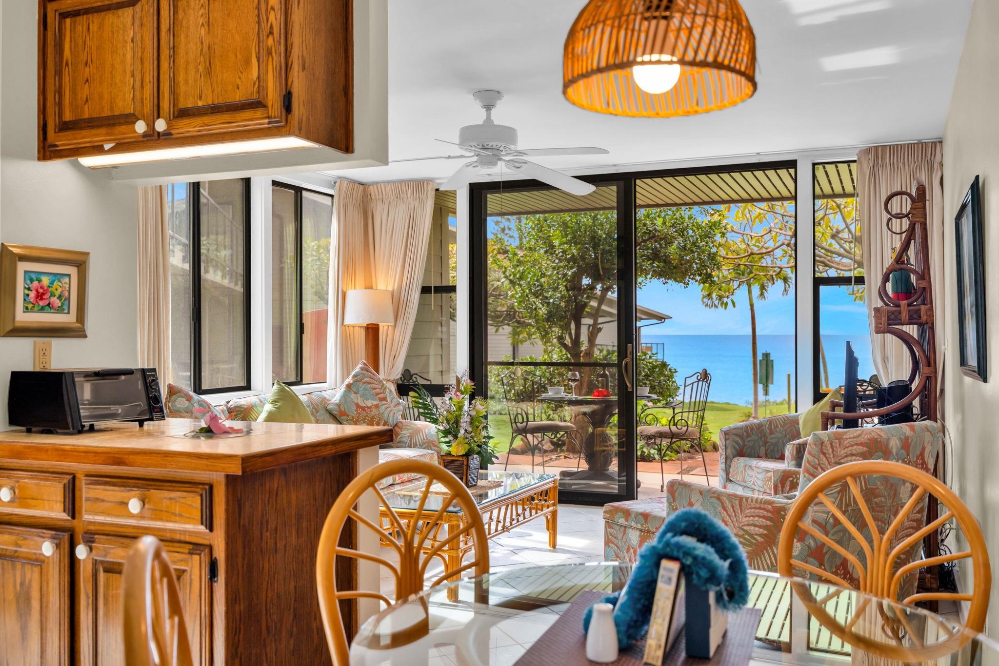 4057 Lower Honoapiilani Road, Unit 116 Lahaina, HI 96761 - Photo 21 of 38 a dining room with furniture a chandelier and a rug