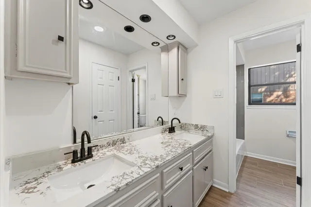 a bathroom with a granite countertop sink and a mirror