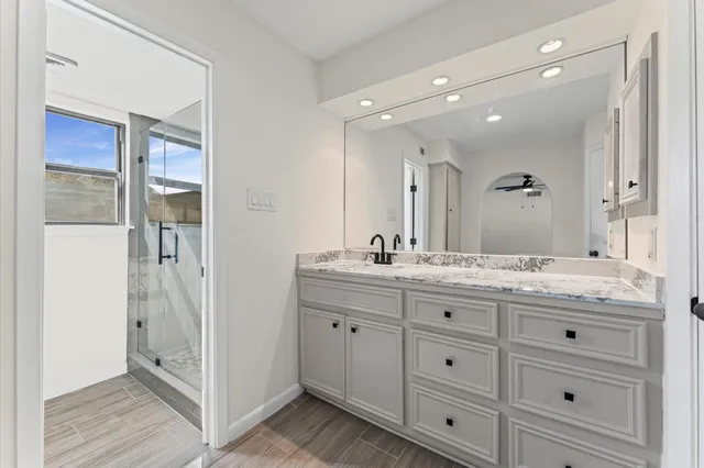 a bathroom with a granite countertop double vanity sink mirror and
