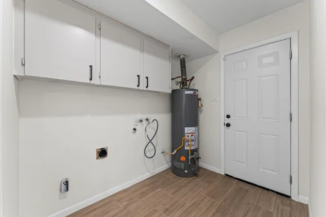 a view of water heater room with hallway and wooden floor