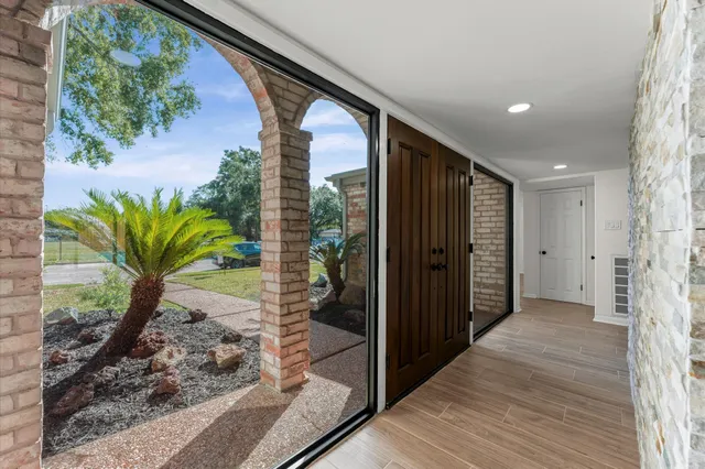 a view of a hallway with wooden floor and a potted plant