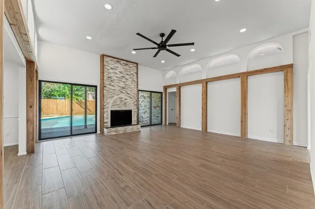 a view of an empty room with a fireplace and a window