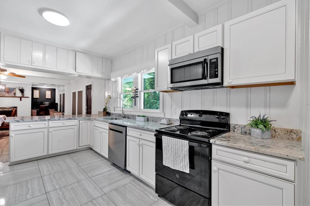 8 South Hughes Street Rome, GA 30165 - Photo 7 of 28 a kitchen with stainless steel appliances granite countertop grey cabinets a stove a sink and a microwave