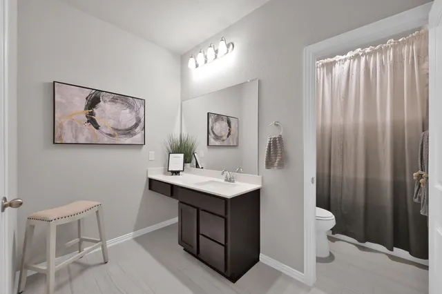 a bathroom with a toilet a sink and mirror