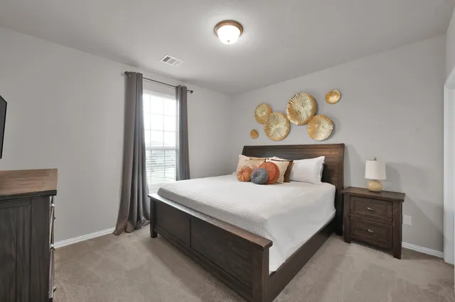 a large bed sitting in a bedroom next to a window