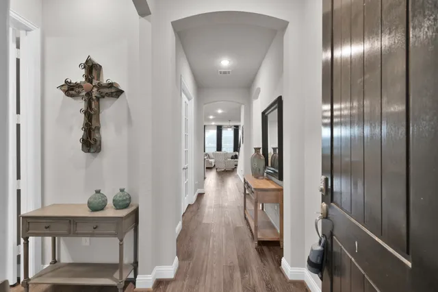 a view of a hallway with wooden floor fireplace and livingroom view