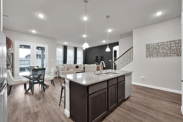a large kitchen with lots of counter space a sink and chairs