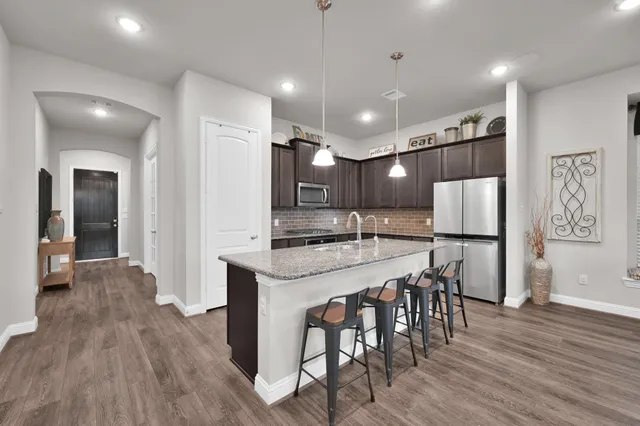 a large kitchen with a table and chairs