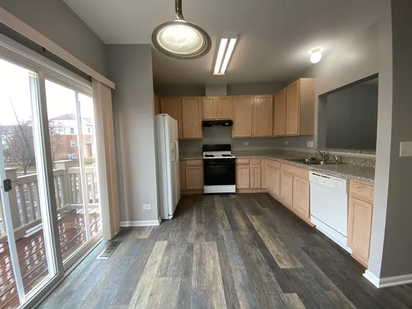a kitchen with granite countertop a stove top oven sink and cabinets