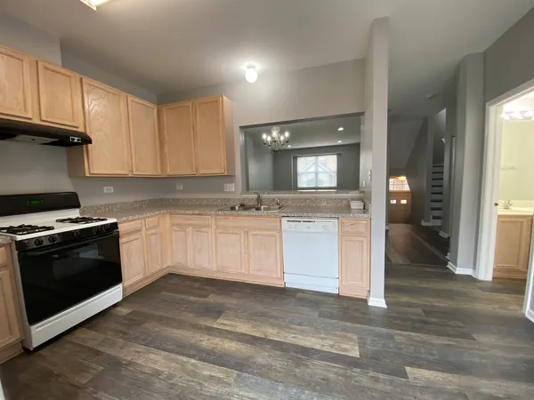 a kitchen with granite countertop white cabinets and stainless steel appliances