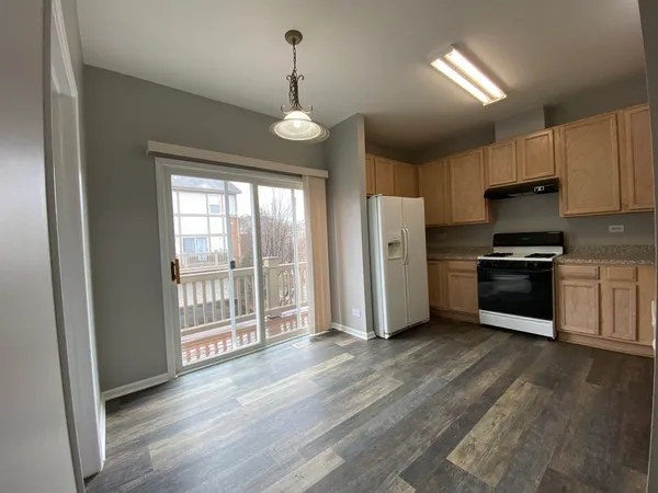 a kitchen with stainless steel appliances a refrigerator and a wooden floor