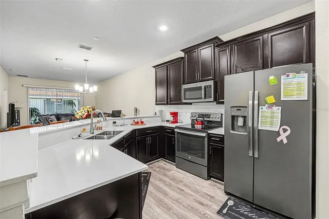 a kitchen with stainless steel appliances a refrigerator sink and microwave