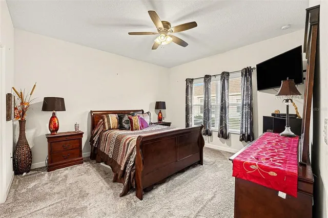 a spacious bedroom with a bed a couch and a chandelier