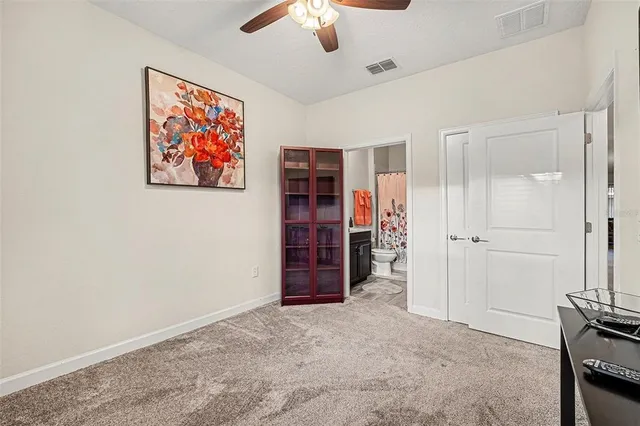 an empty room with closet and a ceiling fan