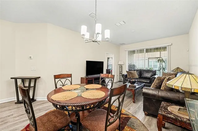 a living room with furniture a chandelier and a flat screen tv