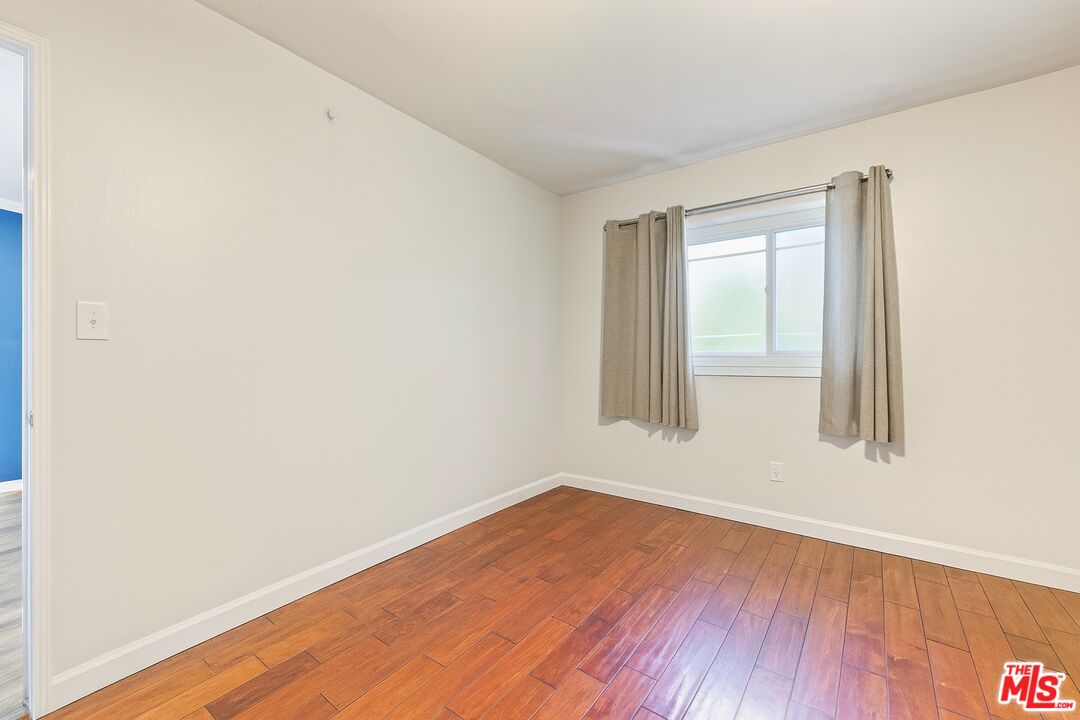 5014 Nobel Street Commerce, CA 90040 - Photo 10 of 11 an empty room with wooden floor and windows