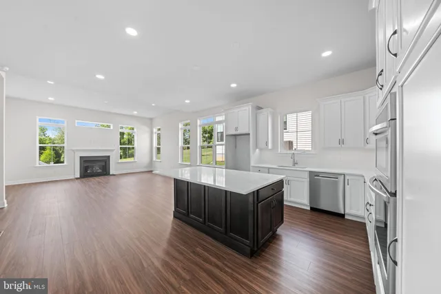 a kitchen with a sink dishwasher stove and wooden cabinets
