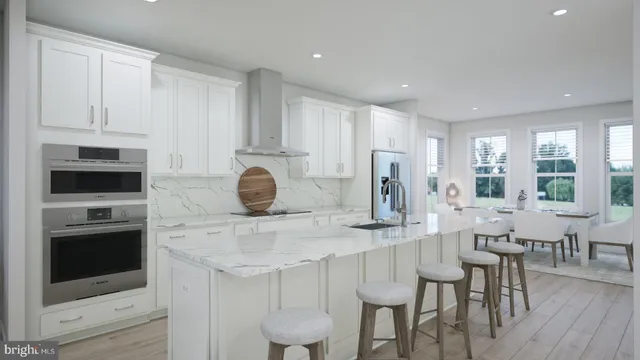 a kitchen with stainless steel appliances granite countertop a stove a sink a microwave a dining table and chairs